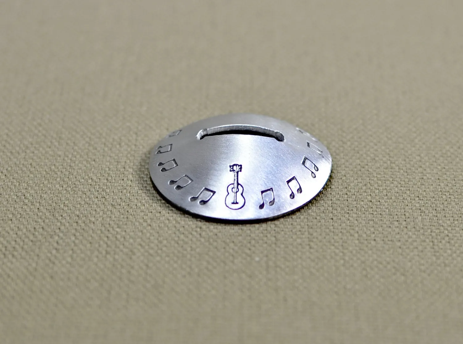 Aluminum disc shaped guitar pick stand with musical inspiration