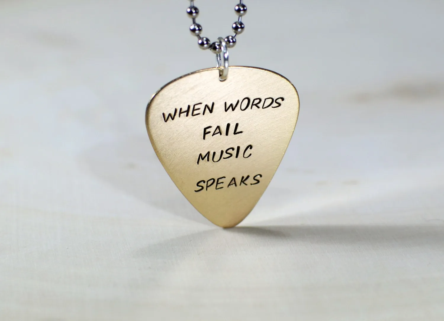 Bronze guitar pick necklace when words fail