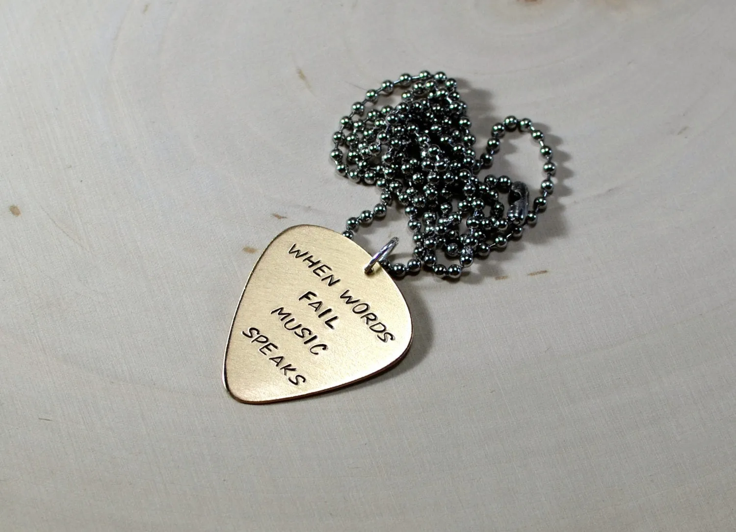 Bronze guitar pick necklace when words fail