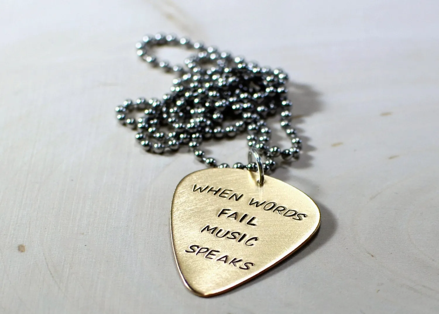 Bronze guitar pick necklace when words fail