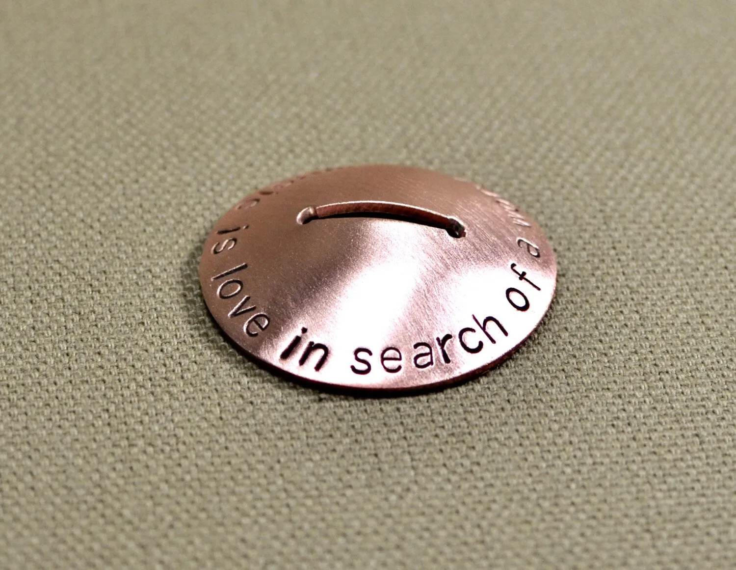 Copper guitar pick stand with "music is love in search of a word