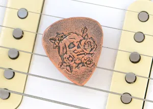 Guitar pick in copper with skull and roses