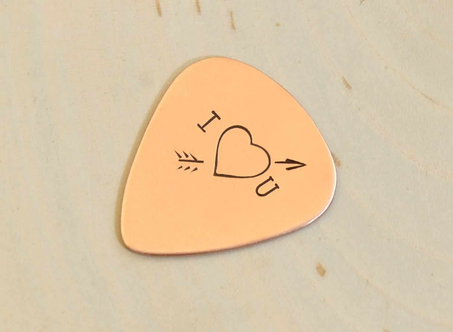 I love you copper guitar pick with Cupid's arrow of love straight through the heart