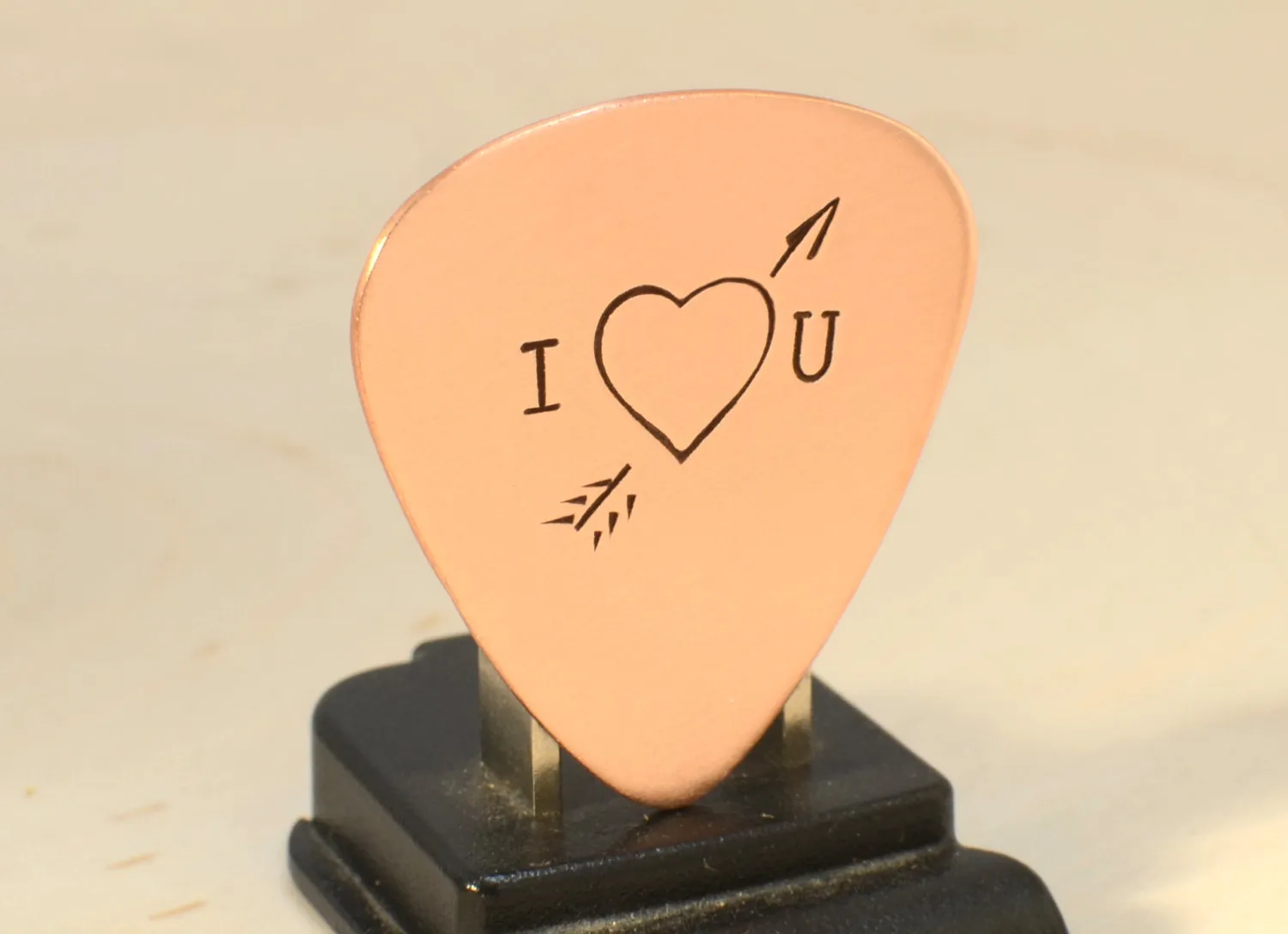 I love you copper guitar pick with Cupid's arrow of love straight through the heart
