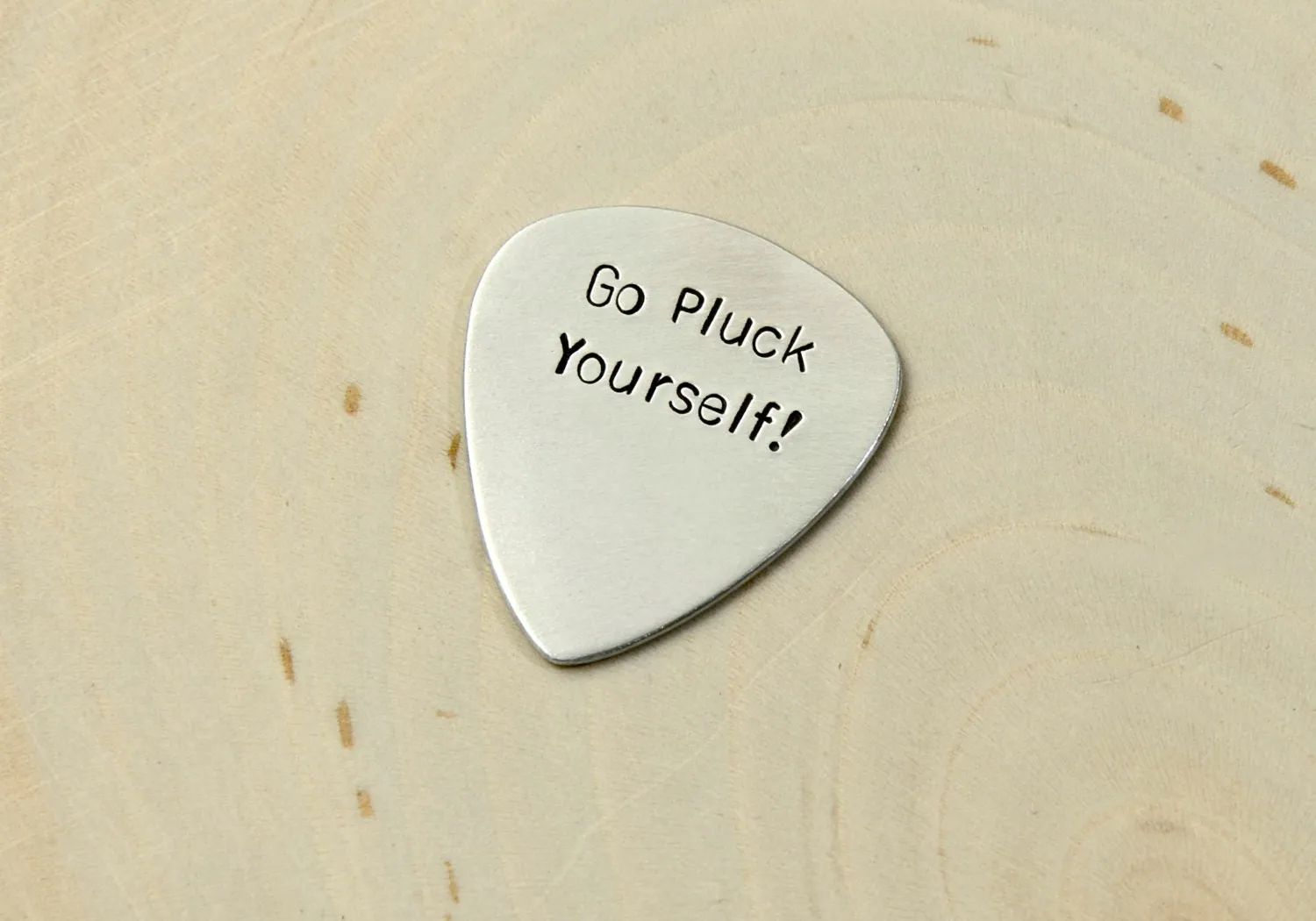 Silver guitar pick with Go Pluck Yourself